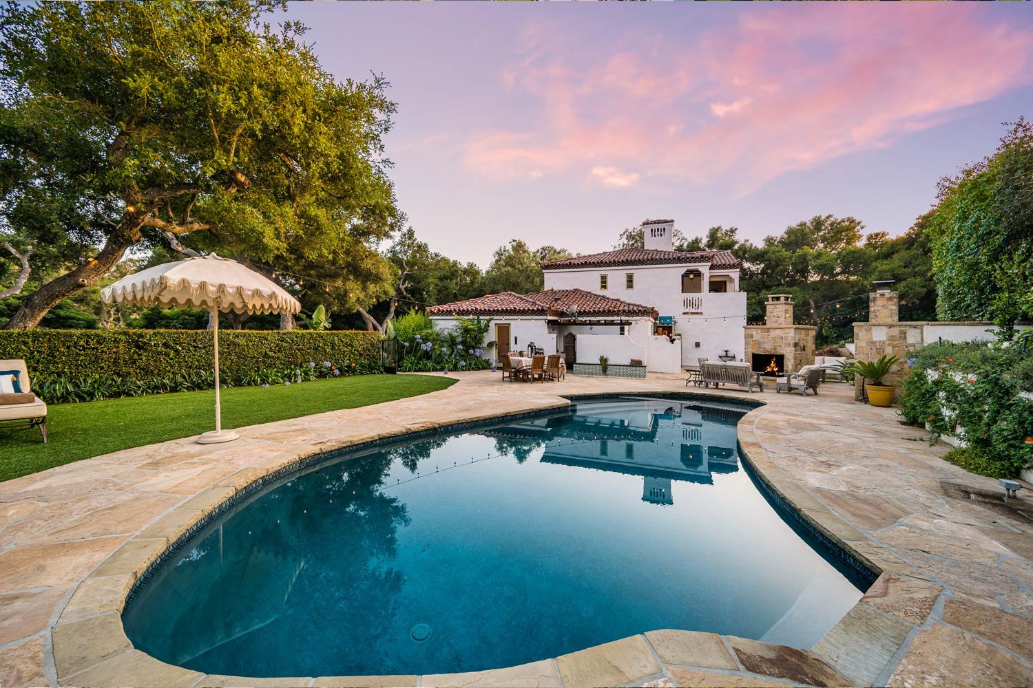 Fotografía de una casa con alberca al atardecer.